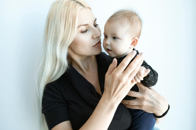 Woman in Black Shirt Carrying Baby