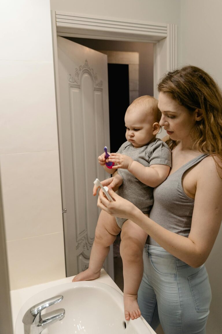 Woman in Gray Tank Top Carrying Baby